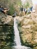 Seven people standing at the top of a waterfall in goofy poses